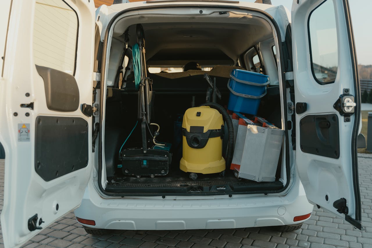about-us-01 A van with cleaning supplies reveals its open trunk filled with tools and equipment.